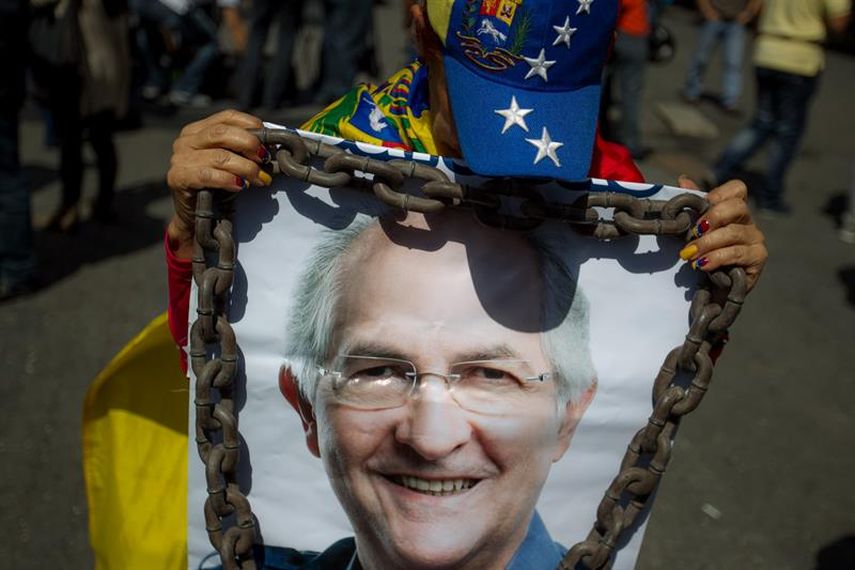 Una manifestante sostiene un afiche con el rostro del alcalde metropolitano de Caracas, en una marcha para protestar contra su detención. (EFE) 
