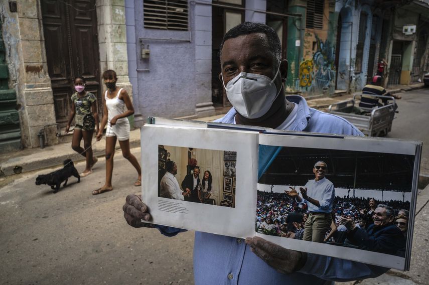En esta foto de archivo del 22 de octubre de 2020 con una máscara facial en medio de la nueva pandemia de coronavirus, Cristóbal Márquez, dueño de Cristobals, el restaurante donde Michelle y Barak Obama almorzaron durante su visita a Cuba en 2016, muestra el libro realizado por el fotógrafo de la Casa Blanca Pete Souza, en La Habana, Cuba.&nbsp;
