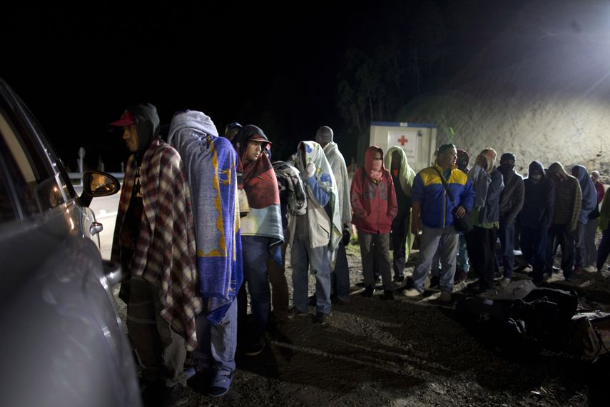 En esta imagen del 31 de agosto de 2018, migrantes venezolanos hacen fila para recibir pan y caf&eacute; donado por una familia colombiana que atiende desde su auto, en una gasolinera de Pamplona, Colombia. Archivo.