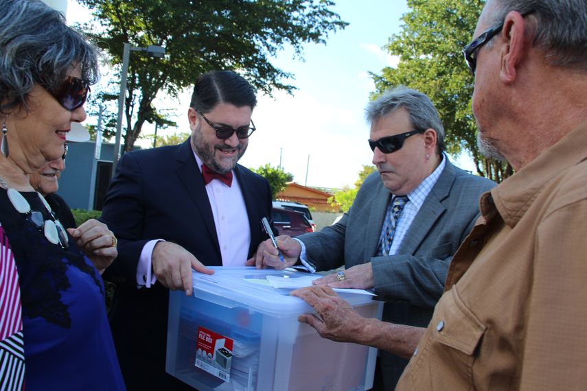 El abogado Juan Carlos Planas (centro), junto a miembros del grupo apoyo, prepara las firmas para entregar a la autoridad electoral.