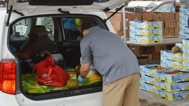 Los productos alimentarios son depositados en los maleteros de los vehículos.