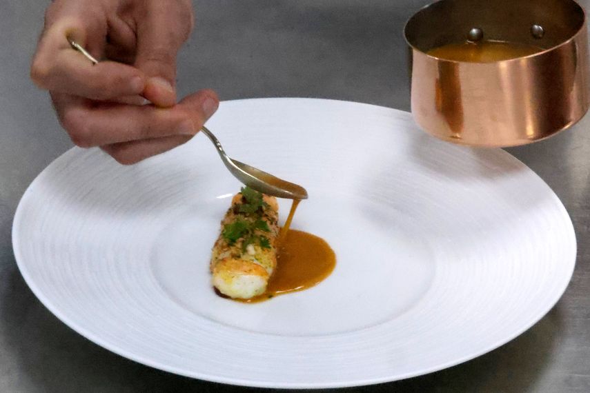 Un chef prepara un plato en las cocinas del restaurante STAY by Yannick Alleno en Dubai el 7 de julio de 2023.