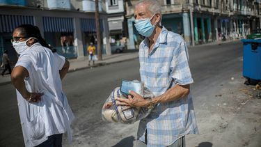Un cubano lleva entre sus manos una ración mensual de alimentos.