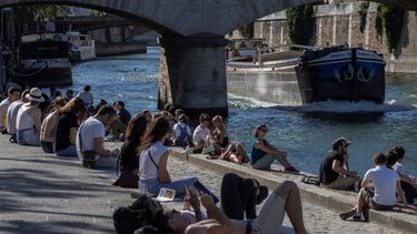 Unas personas se sientan en la orilla del r&iacute;o Sena en Par&iacute;s, el jueves 28 de mayo de 2020.&nbsp;