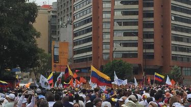 Manifestantes llevan la bandera de Venezuela durante la marcha convocada por Juan Guaidó en Caracas.