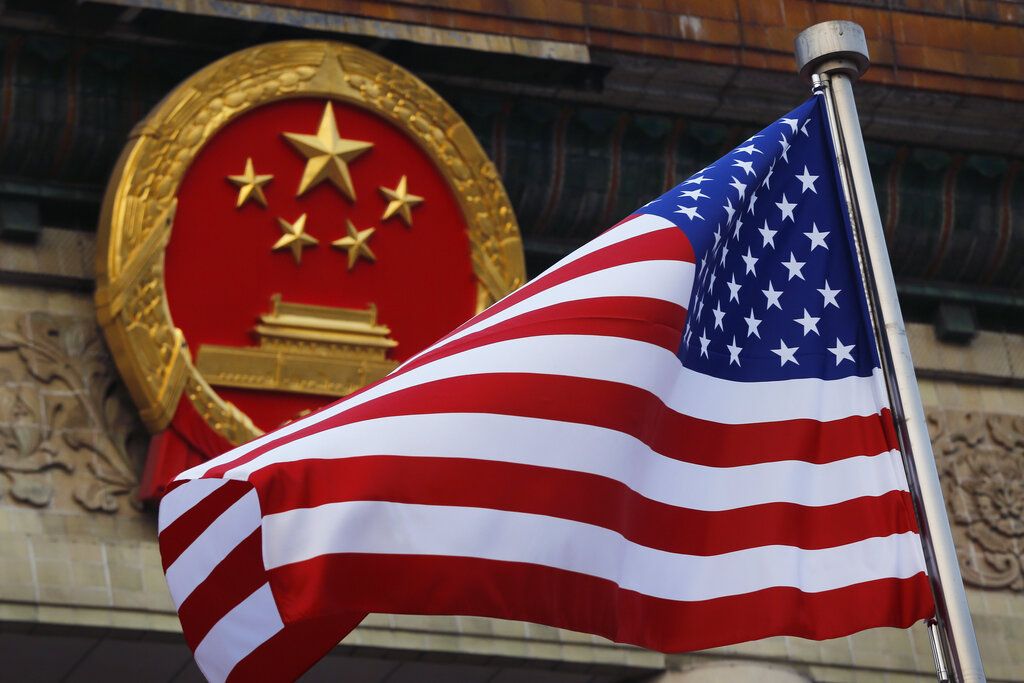 Una bandera estadounidense junto al emblema nacional de China en una ceremonia de bienvenida a visitantes estadounidenses. Una bandera estadounidense junto al emblema nacional de China en una ceremonia de bienvenida a visitantes estadounidenses.