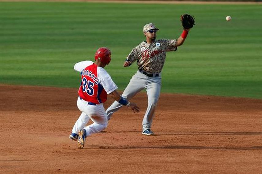 El jugador de Ciego de Ávila Yorbis Borroto (35) es puesto out por Juniel Querecuto, de los Tigres de Aragua. (EFE)