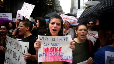 ¿Por qué hay tanta injusticia en el sistema judicial?, dice uno de los carteles que sostienen las mujeres que protestan contra la posible confirmación del juez Brett Kavanaugh para el Tribunal Supremo.