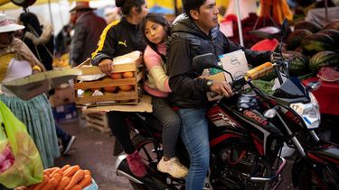 Una familia transporta frutas y verduras en su motocicleta en un mercado popular de comida en Puno, Perú, el 29 de enero de 2023.