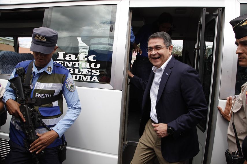 Fotograf&iacute;a de archivo fechada el 11 de marzo de 2019 del presidente hondure&ntilde;o, Juan Orlando Hern&aacute;ndez (der.), mientras desciende de un autob&uacute;s&nbsp;para participar en un acto p&uacute;blico en Tegucigalpa, Honduras.