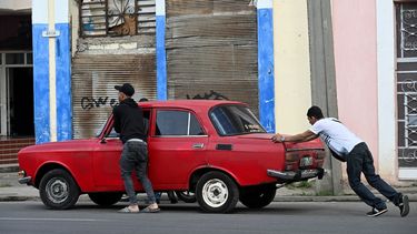 Unos hombres empujan un automóvil cerca de una gasolinera en La Habana, Cuba, el 11 de diciembre de 2024. 