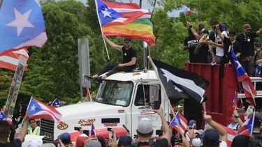 El cantante Ricky Martin, sosteniendo una bandera de Puerto Rico, participa en la marcha en protesta multitudinaria contra el gobierno de Ricardo Rosselló, en San Juan.&nbsp;