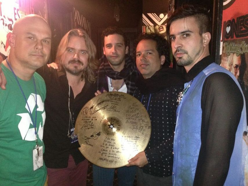 Miembros de la agrupación junto al platillo que subastan. (EBAY)