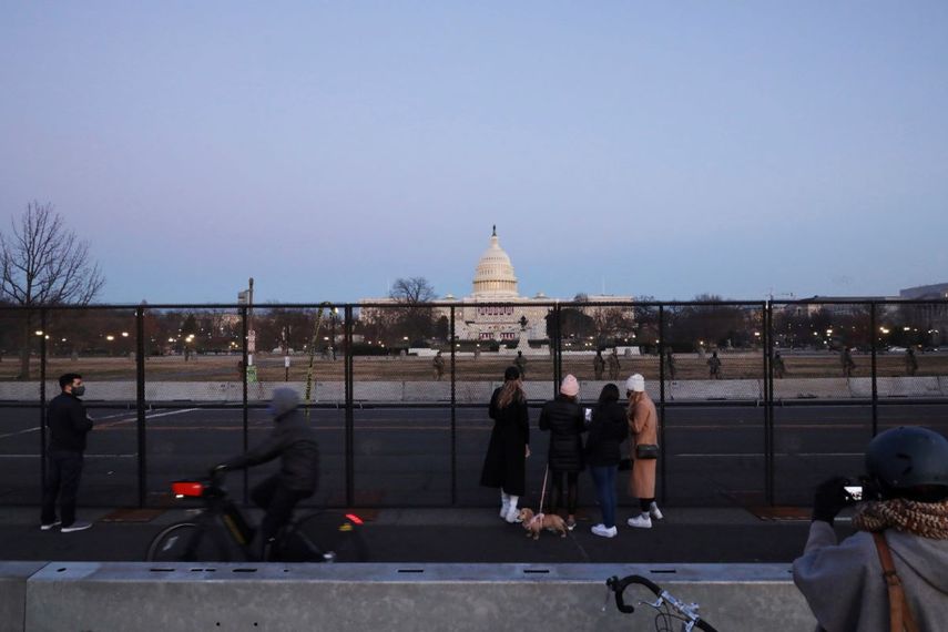 Personas junto a una valla de seguridad alrededor del Capitolio de Estados Unidos el miércoles 13 de enero de 2021, en Washington, D.C.&nbsp;