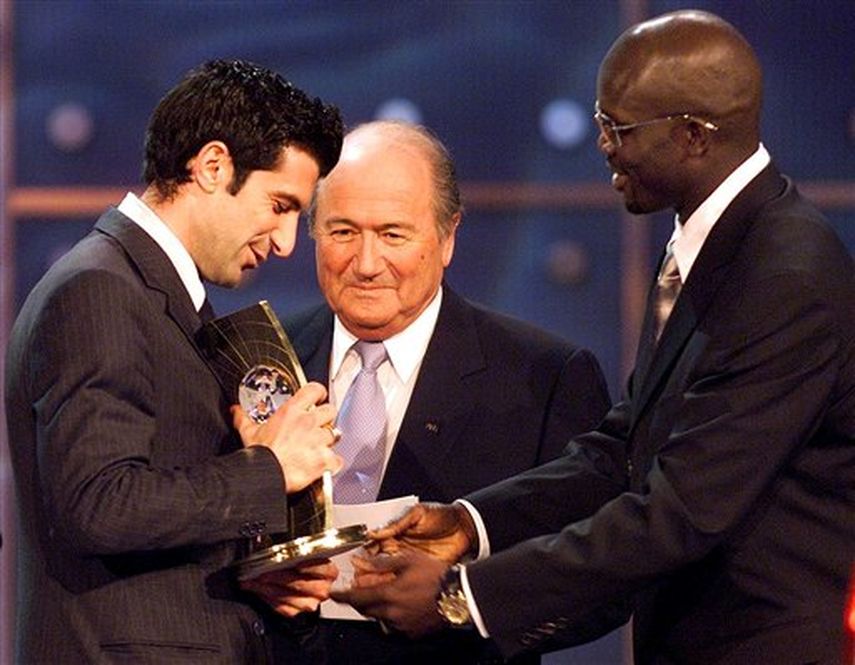 En 2001, Figo (izquierda) recibió el Balón de Oro de manos de Joseph Blatter (centro), a quien ahora enfrenta por la presidencia de la FIFA, y de George Weah. (AP)