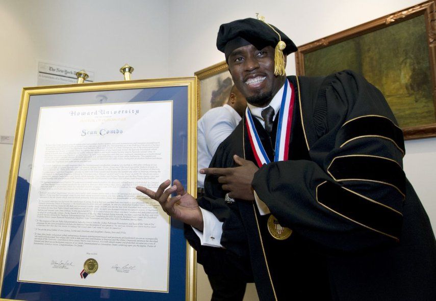 El artista y empresario Sean Diddy Combs posa junto a su título honorífico de Doctor en Humanidades durante la ceremonia de graduación en la Universidad Howard en Washington, el sábado 10 de mayo de 2014.