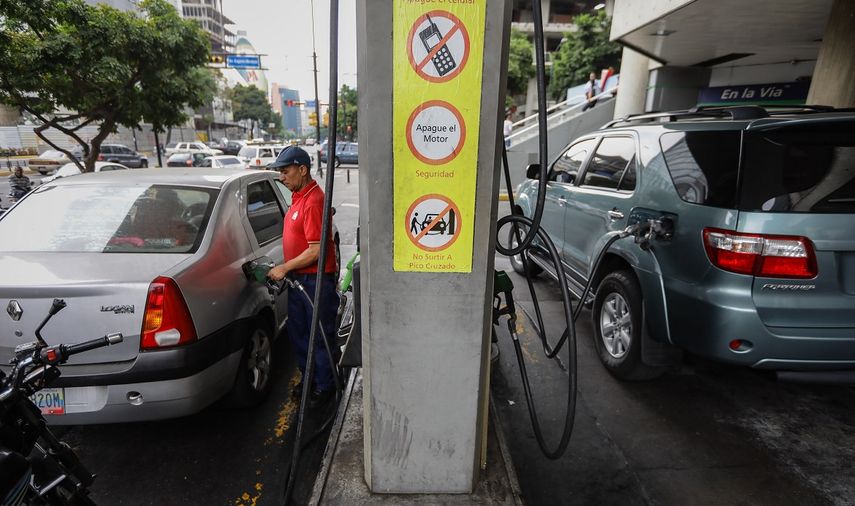 Un trabajador llena con gasolina el tanque de un vehículo en una estación de servicio en Caracas, Venezuela.