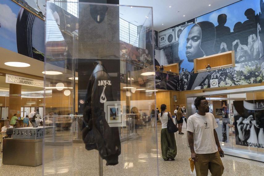 La gente visita la retrospectiva El libro de HOV: una celebración de la vida y obra de Shawn JAY-Z Carter, en la Biblioteca Pública de Brooklyn en el distrito de Brooklyn de la ciudad de Nueva York el 17 de julio de 2023. La exposición, que se extenderá durante el verano, presenta obras de arte, música y recuerdos de la carrera de Jay-Z.