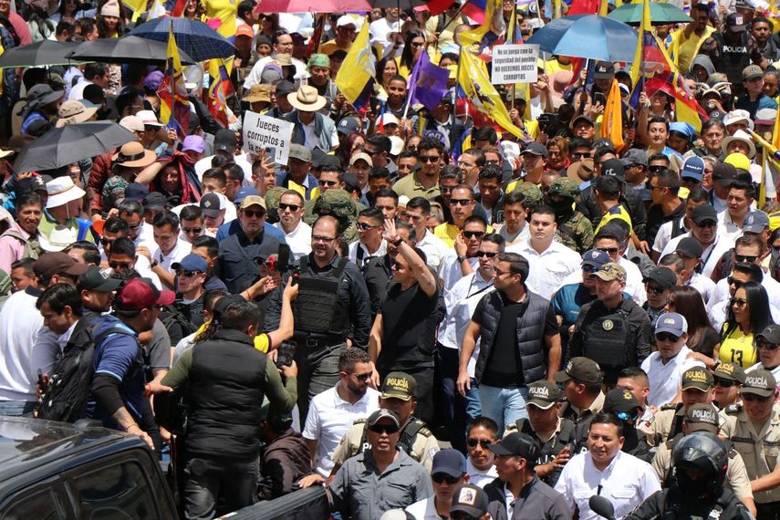 El presidente de Ecuador, Daniel Noboa (centro, derecha), y el ministro del Interior, John Reimberg (centro, izquierda), marchan contra la decisión de la Corte Constitucional de censurar varios artículos de leyes recientes en Quito, el 12 de agosto de 2025. 