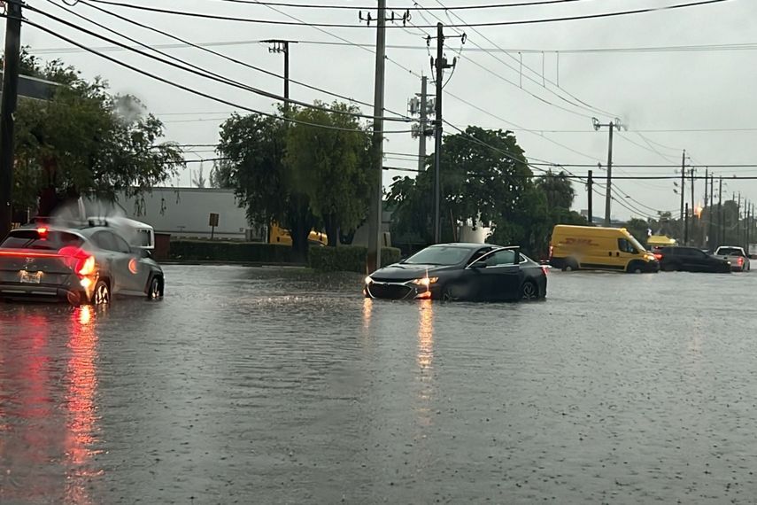Un auto queda atrapado en una calle inundada, debido a las fuertes lluvias en Florida.