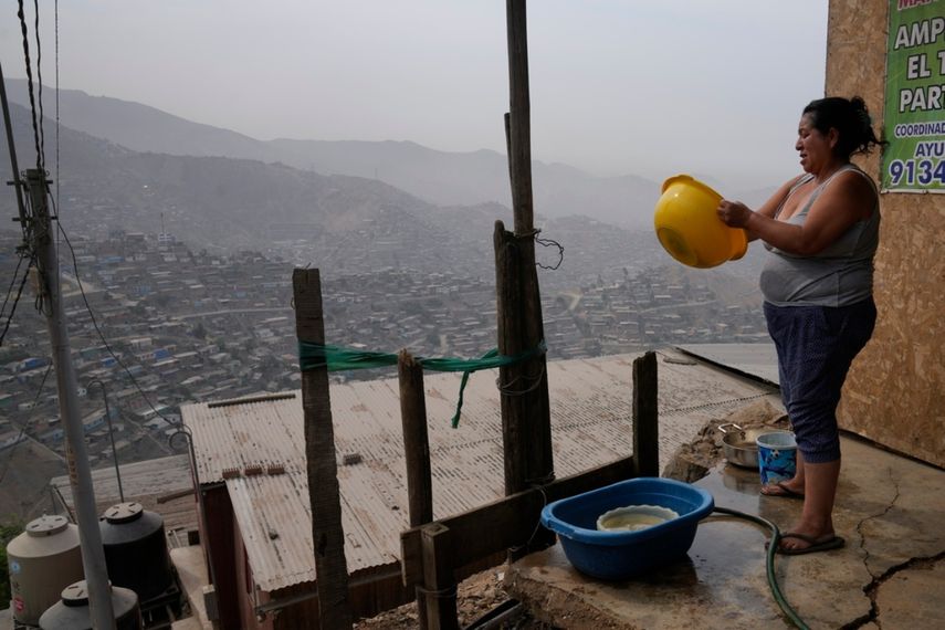 Justina Flores lava los platos en el exterior de su casa en la zona de Pamplona Alta, en Lima, Perú, el 7 de marzo de 2024. El gobierno de Perú suministra agua potable a 1,5 millones de sus habitantes más pobres, como Flores, que viven en las colinas. 