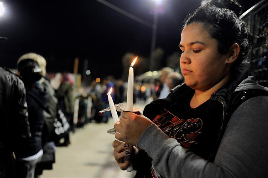  Una mujer sostiene una vela encendida en una vigilia por las víctimas de un tiroteo en San Bernardino, California.(EFE) 