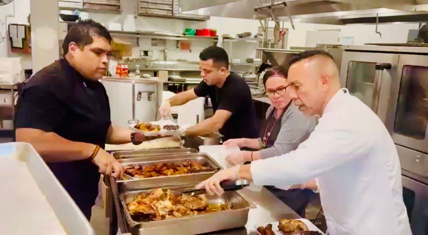 Juan Chipoco y el equipo organizador sirven alimentos a personas necesitadas.