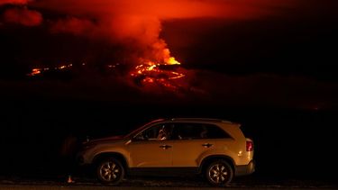 Un hombre conversa por teléfono desde su auto a lo largo de Saddle Road, la principal carretera que une las costas este y oeste de la Isla Grande de Hawai, al tiempo que el volcán Mauna Loa hace erupción el miércoles 30 de noviembre de 2022, cerca de Hilo, Hawai.&nbsp;