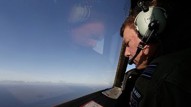 Brett McKenzie, copiloto de un avión Orión P-3K2 de la fuerza aérea neozelandesa observa por la ventanilla en busca de restos del vuelo 370 de Malaysia Airlines sobre el océano Indico el sábado 29 de marzo de 2014. (Foto AP/Jason Reed, Pool)