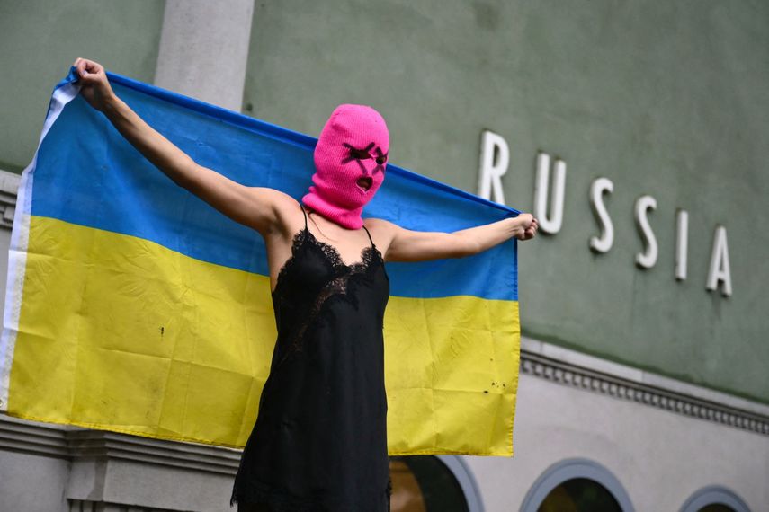 Una integrante del grupo activista Pussy Riot sostiene una bandera ucraniana durante una protesta contra la participación de Rusia en la Bienal de Venecia, frente al pabellón ruso, el 6 de mayo de 2026 en Venecia.