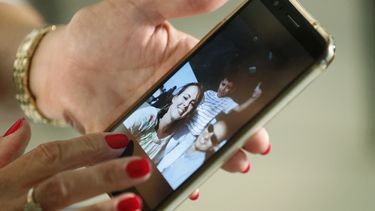 En esta imagen, tomada el 20 de junio de 2019, Mary Sardinas, de 60 a&ntilde;os, muestra una fotograf&iacute;a de su hijo, su nuera y su nieto en Cuba durante una entrevista con The Associated Press en Miami.&nbsp;
