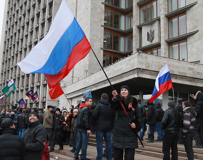 Activistas prorrusos agitan banderas rusas frente a la municipalidad de Donetsk, Ucrania, 2 de marzo de 2014. Una multitud con banderas rusas asaltó la sede municipal de Donetsk el miércoles 5 de marzo de 2014, dijo un fotógrafo de la AP. (AP Foto/Serg