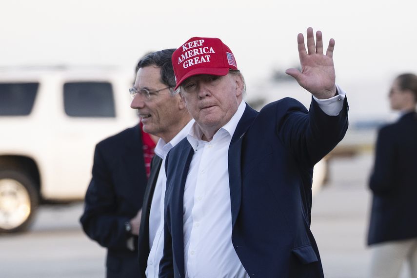 El presidente Donald Trump saluda mientras desciende del avión presidencial acompañado por el senador John Barraso, en el Aeropuerto Internacional de Palm Beach, el viernes 29 de noviembre de 2019, en West Palm Beach, Florida.