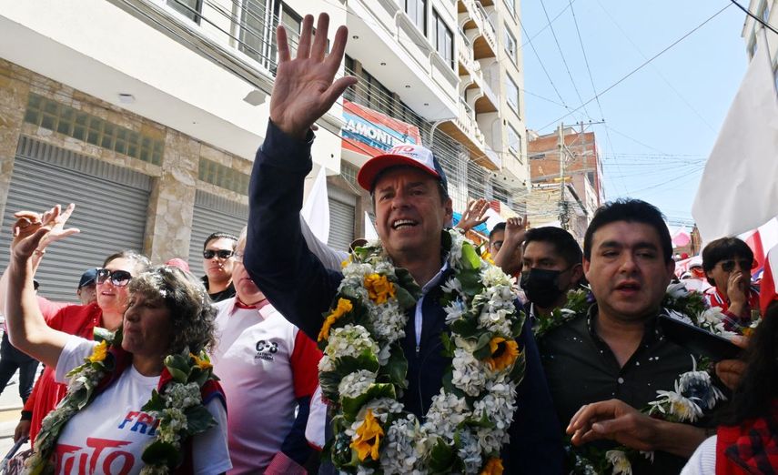 El expresidente boliviano y candidato presidencial de la coalición Alianza Libre, Jorge Tuto Quiroga Ramírez (centro), saluda a sus simpatizantes durante una visita al mercado de abastos Vicente Ochoa en La Paz el 7 de agosto de 2025. Bolivia celebrará elecciones presidenciales el 17 de agosto.&nbsp;