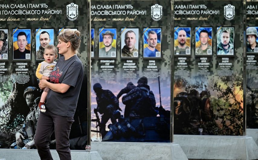 Una mujer reacciona mientras sostiene a su bebé en el Callejón de los Héroes Caídos, en un distrito de Kiev, el 12 de julio de 2026, en medio de la invasión rusa de Ucrania.&nbsp;