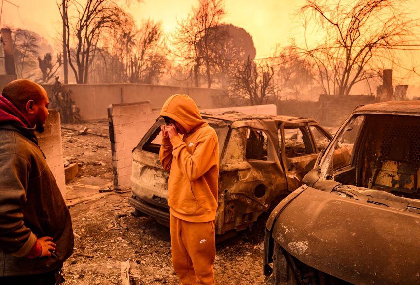 Dos personas entre cenizas y escombros que dejaron las llamas de uno de los incendios en Altadena, en el condado Los Angeles, California.