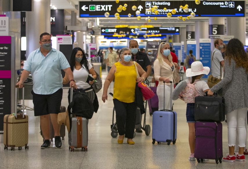 Viajeros con mascarillas caminan el domingo 22 de noviembre por el Aeropuerto Internacional de Miami. &nbsp;