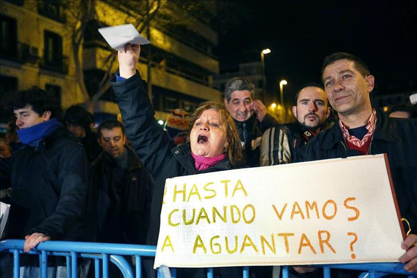 Manifestantes muestran pancartas durante una concentración en la que varios centenares de asistentes han protestado contra la corrupción en la sede del PP en Madrid. EFE