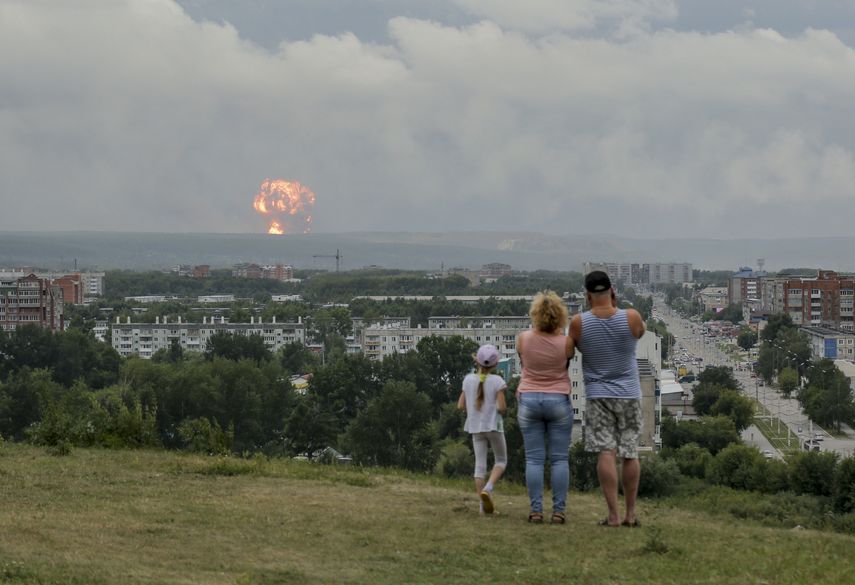En esta imagen tomada el 5 de agosto de 2019, una familia observa las explosiones en un depósito militar cerca de la ciudad de Achinsk, en la región de Krasnoyarsk, en el este de Siberia, Rusia.&nbsp;