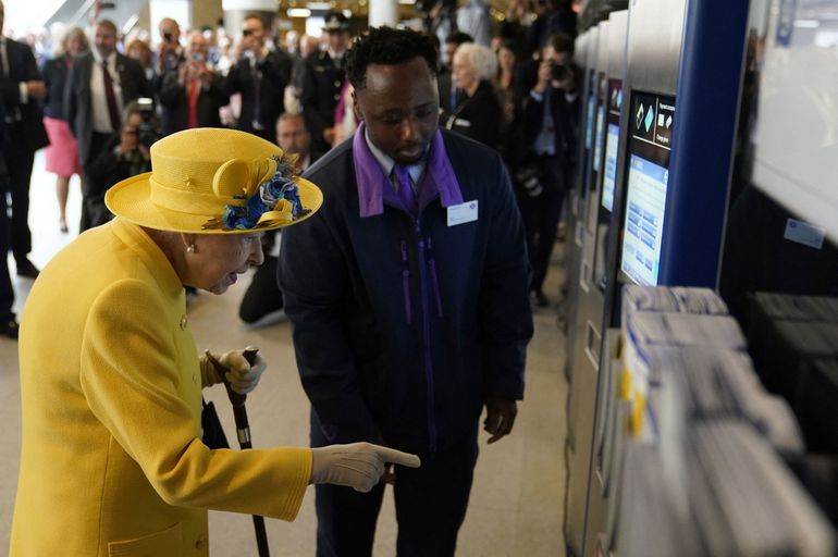 La reina Isabel II de Gran Bretaña usa una máquina expendedora de boletos Oyster Card durante su visita a la estación de Paddington en Londres el 17 de mayo de 2022.
