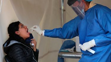 Un trabajador de la salud toma una muestra de la garganta de una mujer para hacer una prueba de detección de COVID-19 en Ciudad de México el sábado 10 de julio de 2021
