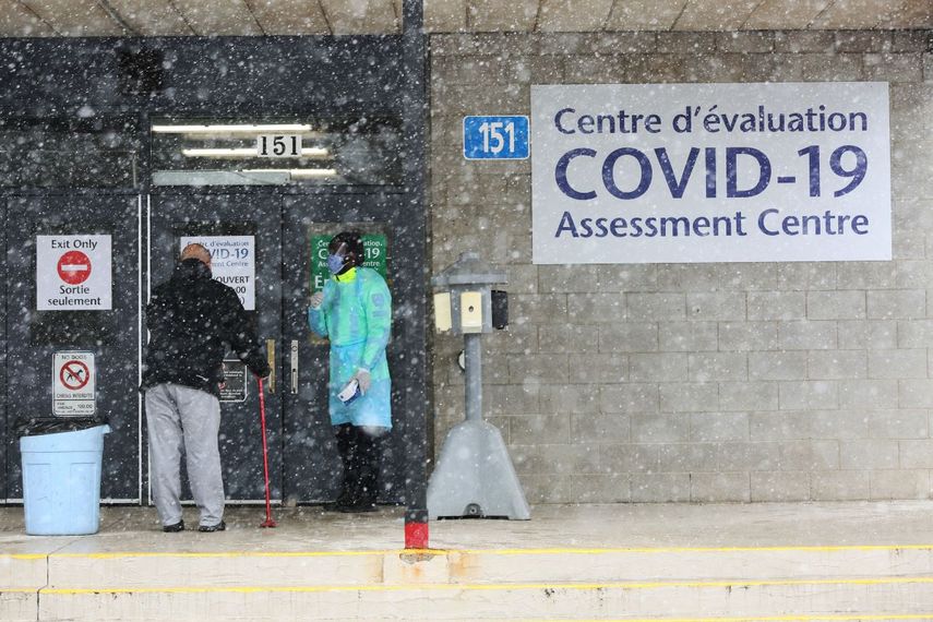 Un oficial de Salud P&uacute;blica de Ottawa (derecha) habla con la siguiente persona en la fila en el centro de pruebas COVID-19, el 23 de marzo de 2020 en Ottawa, Canad&aacute;.