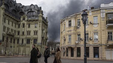 Personas caminan por una calle cerca de humo por un ataque en Odesa, Ucrania, el 3 de abril de 2022. Unesco puso a la ciudad en en su lista de lugares en peligro.