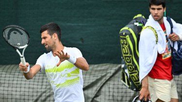El español Carlos Alcaraz (D) observa el entrenamiento de Novak Djokovic de Serbia antes del inicio del Campeonato de Wimbledon 2023 en el All England Tennis Club en Wimbledon, suroeste de Londres, el 2 de julio de 2023.
