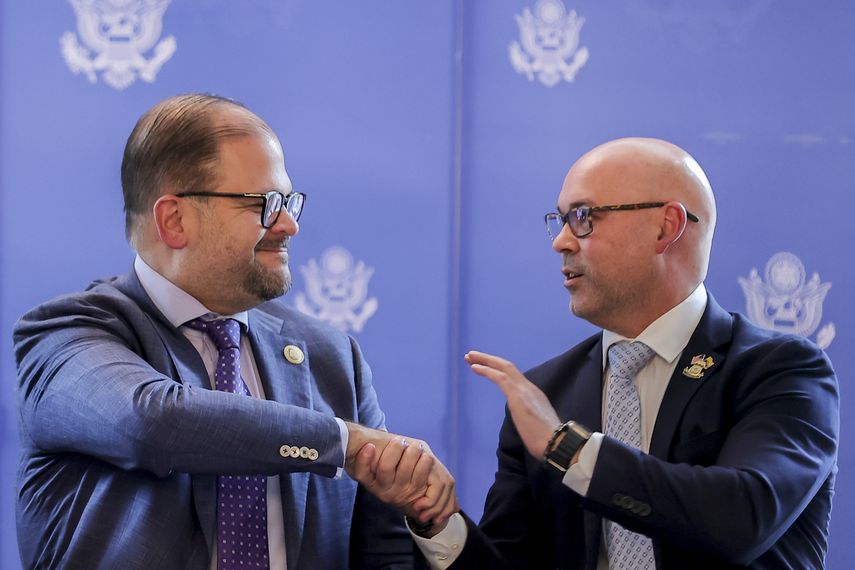 El ministro del Interior de Ecuador, John Reimberg (i), estrecha la mano del delegado de la Oficina de Investigaciones de Seguridad Nacional de EEUU, Héctor Quintana (d), tras la firma de un acuerdo de seguridad, en Quito, el 20 de abril 2026.