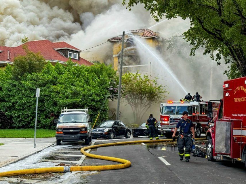 Bomberos y policías de Miami trabajan extinguiendo un incendio en el edificio de departamentos Temple Court Apartments, el lunes 10 de junio de 2024 en Miami.