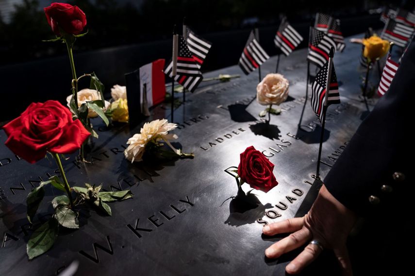 Un bombero coloca su mano sobre los nombres tallados en el ala sur durante las ceremonias para conmemorar el 20mo aniversrio de los ataques terroristas del 11 de septiembre. Museo Nacional del 11 de Septiembre, en Nueva York.