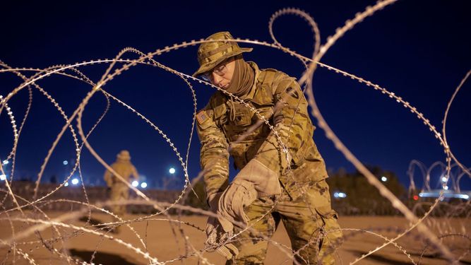 Un soldado de la Guardia Nacional de Texas amarra hileras de alambre de púas que será instalado cerca de una entrada en la valla fronteriza, en El Paso, Texas.&nbsp;