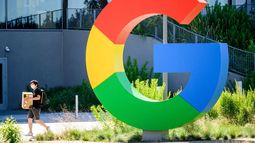 Un joven camina cerca del logo del gigante Google.