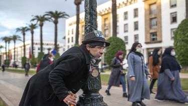 El mimo Belhussein Abdelsalam, quien personifica a Charlie Chaplin, actúa frente a transeúntes en una avenida en Rabat, Marruecos, el 17 de diciembre de 2020.
